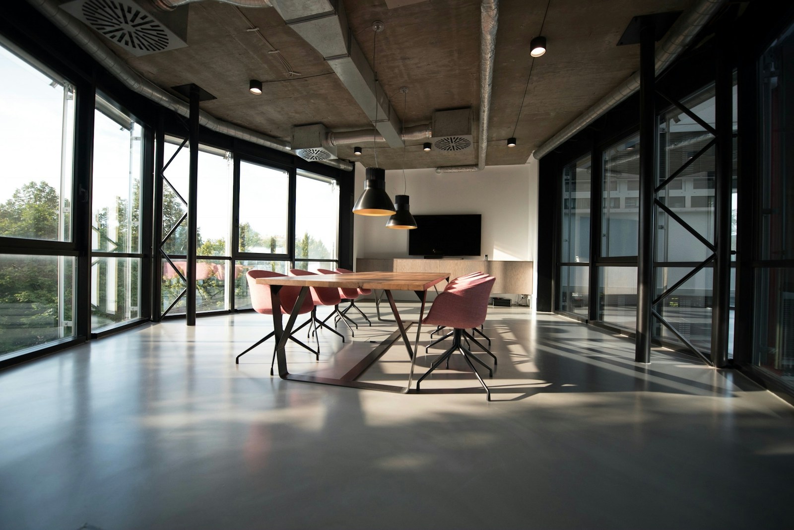 Sunlight filling a welcoming workspace, with a long table ready for a conversation
